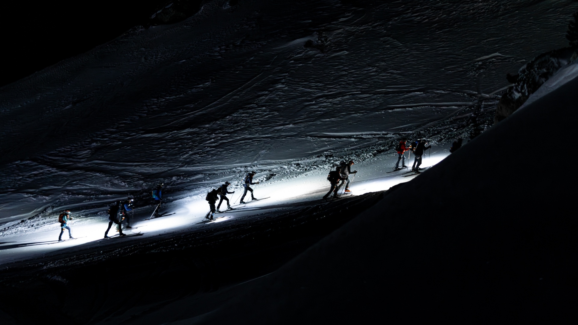 Skieurs-alpinistes en progression de nuit lors de la Patrouille des Glaciers en Suisse